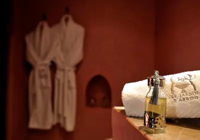 a bottle of oil sitting on a counter next to towels at Riad Le Jardin d'Abdou in Marrakech