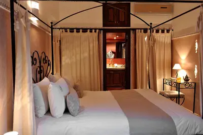 a bedroom with a large bed with white pillows at Riad Le Jardin d'Abdou in Marrakech