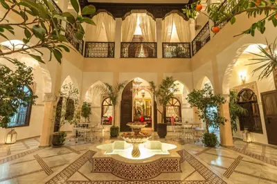 a large lobby with a fountain in the middle of a building at Riad Nasreen in Marrakech