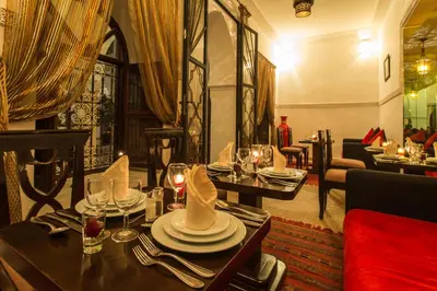a dining room with tables and chairs with wine glasses at Riad Nasreen in Marrakech