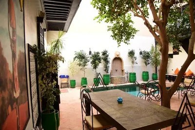 a patio with a table and chairs and a pool at Riad Du Petit Prince in Marrakech