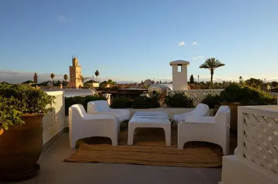 a group of white chairs and a table on a balcony at Riad O in Marrakech