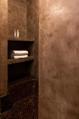 a bathroom with a shelf with towels on it at Riad O in Marrakech
