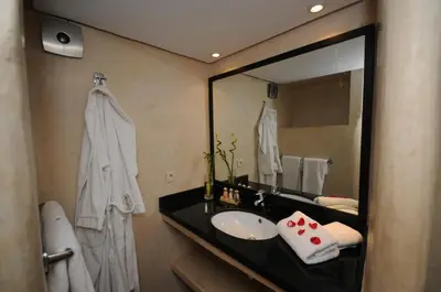 a bathroom with a sink and a large mirror at Riad Vendôme & Spa in Marrakech