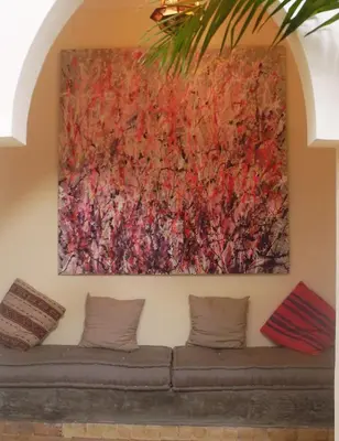 a painting hanging on a wall above a couch at Riad Linda in Marrakech