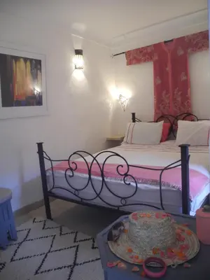 a bedroom with a bed and a table with a cake on it at Riad Linda in Marrakech