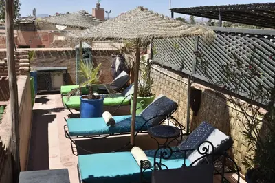 a group of chairs and an umbrella on a patio at Riad Assalam in Marrakech