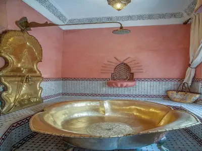 a bathroom with a large gold tub in a room at Riad & Spa Laurence Olivier in Marrakech