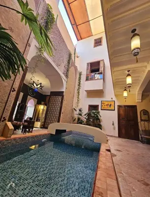 a house with a swimming pool in a courtyard at Riad Sidi Mimoune & Spa in Marrakech