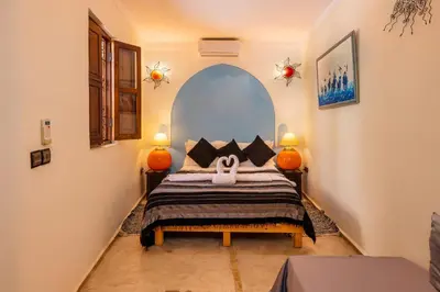 a bedroom with a bed with two lamps on it at Riad Sidi Mimoune & Spa in Marrakech