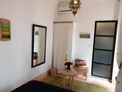 a living room with a table and a mirror at Riad Dar Nouba in Marrakech