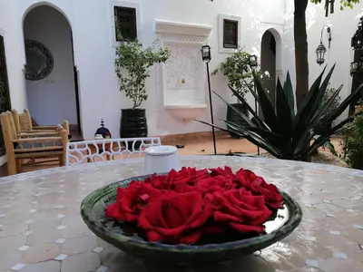 a bowl of red roses sitting on a table at Riad Dar Nouba in Marrakech