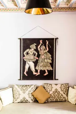 a tapestry hanging on a wall above a couch at Riad Le Rihani in Marrakech