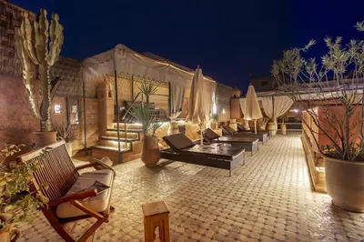 a row of chairs and umbrellas on a patio at night at Dar Sohane in Marrakech