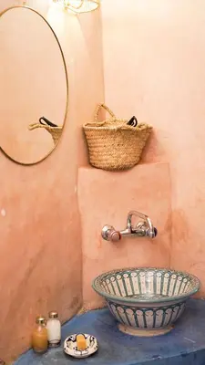a bathroom with a sink and a mirror and a basket at Monriad in Marrakech