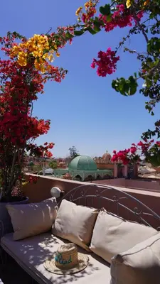 a couch sitting on top of a balcony with flowers at Monriad in Marrakech