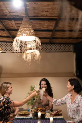 a group of women sitting at a table with drinks at Riad Ajmal in Marrakech