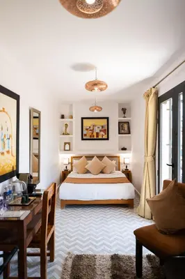 a bedroom with a bed and a couch and a table at Riad Ajmal in Marrakech