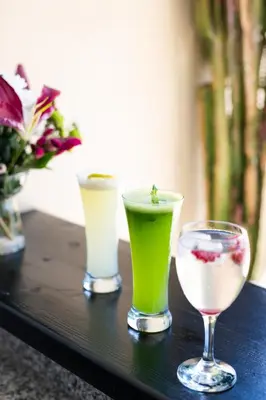 a table with three different drinks and a glass at Riad Ajmal in Marrakech