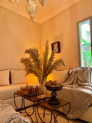 a living room with a couch and a table with chess at Riad Dar More in Marrakech