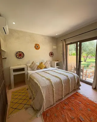 a bedroom with a large bed and a large window at Palais Riad Berbère in Marrakech