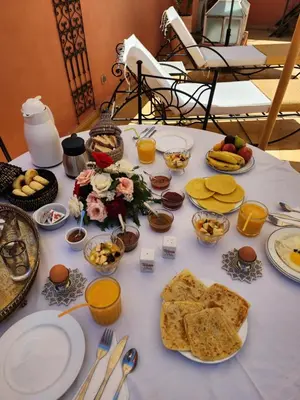 a table topped with plates of food and snacks at Riad Alboraq in Marrakech