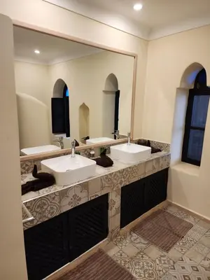 a bathroom with two sinks and a large mirror at Riad Alboraq in Marrakech