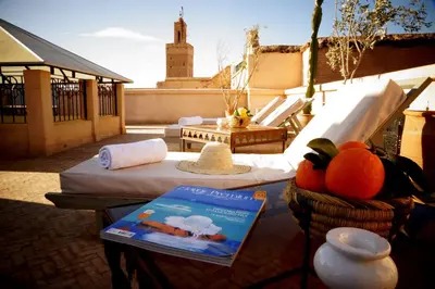 a balcony with a bed and a book on a table at Riad Shama Suites & Spa in Marrakech