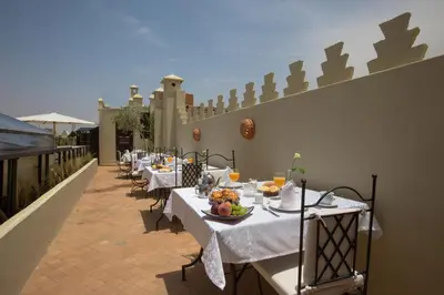 a row of tables with food and drinks on a patio at Riad Kasbah & Spa in Marrakech