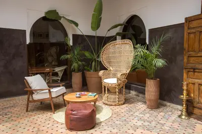 a room with a chair and a table and plants at Riad Kasbah & Spa in Marrakech