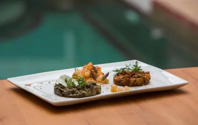 a white plate with food on a wooden table at Riad Kasbah & Spa in Marrakech