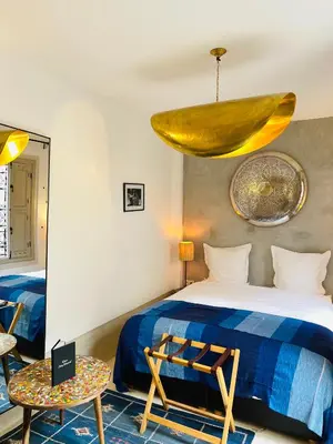 a room with a bed and a table and a mirror at Riad Dar Massai in Marrakech
