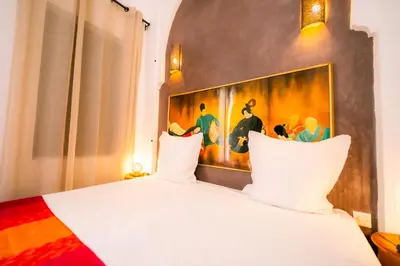 a bedroom with a bed with a painting on the wall at Riad Dar Massai in Marrakech