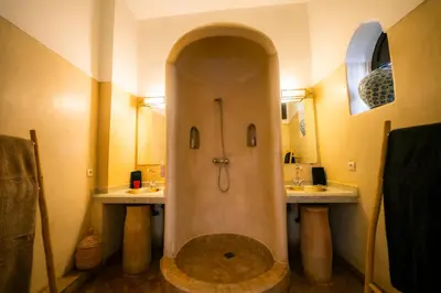 a bathroom with a shower with two sinks at Riad Dar Massai in Marrakech