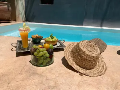 a table with a basket of fruit and a drink at Riad Dar Massai in Marrakech
