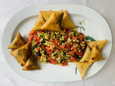 a plate of food with a slice of pizza at Riad Dar Massai in Marrakech