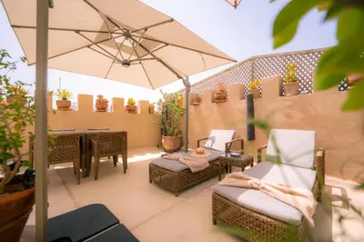 a patio with chairs and an umbrella and a table at Riad Dar Massai in Marrakech