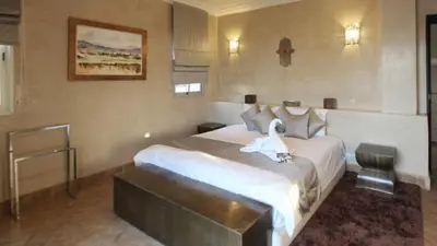 a hotel room with a bed with a swan on it at Palais Ambrine in Marrakech
