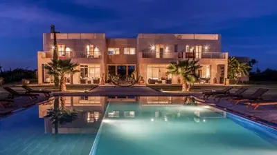 a house with a swimming pool in front of a building at Palais Ambrine in Marrakech