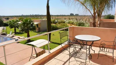 a patio with a table and chairs on a balcony at Palais Ambrine in Marrakech