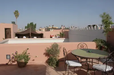 a patio with a table and chairs on a balcony at Riad Cannelle in Marrakech