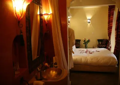 a bathroom with a bed and a sink in a room at Riad Léna & Spa in Marrakech