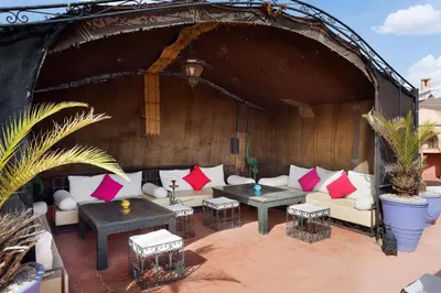an outdoor patio with a white couch and red pillows at Riad Sofia in Marrakech