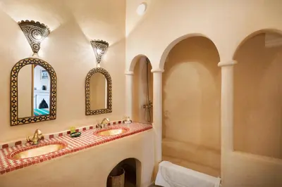 a bathroom with two sinks and two mirrors at Riad Sofia in Marrakech