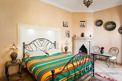 a bedroom with a large bed and a fireplace at Riad Sofia in Marrakech