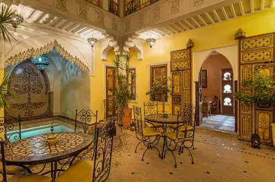 a room with two tables and chairs in a building at Riad Sofia in Marrakech