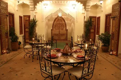 a dining room with tables and chairs in a building at Riad Sofia in Marrakech