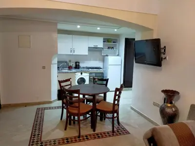 a kitchen and dining room with a table and chairs at Ritaj Apartement in Marrakech