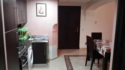 a kitchen with a sink and a table with a dining room at Ritaj Apartement in Marrakech