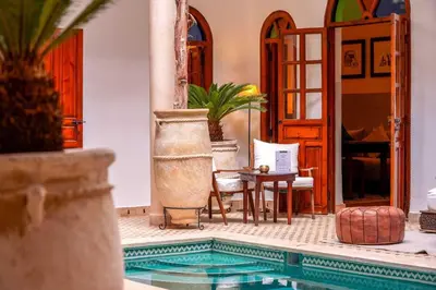a house with a swimming pool with a table and chairs at Riad Adika & Spa in Marrakech